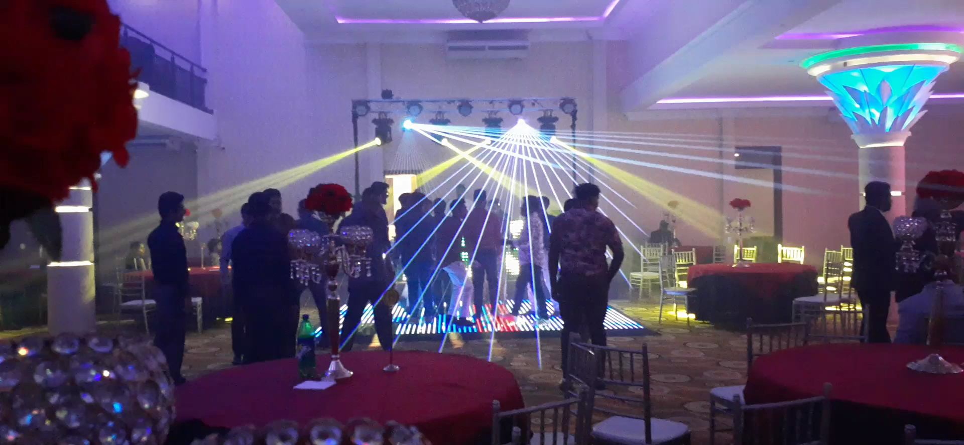 Laser beams over a crowded light-up dance floor