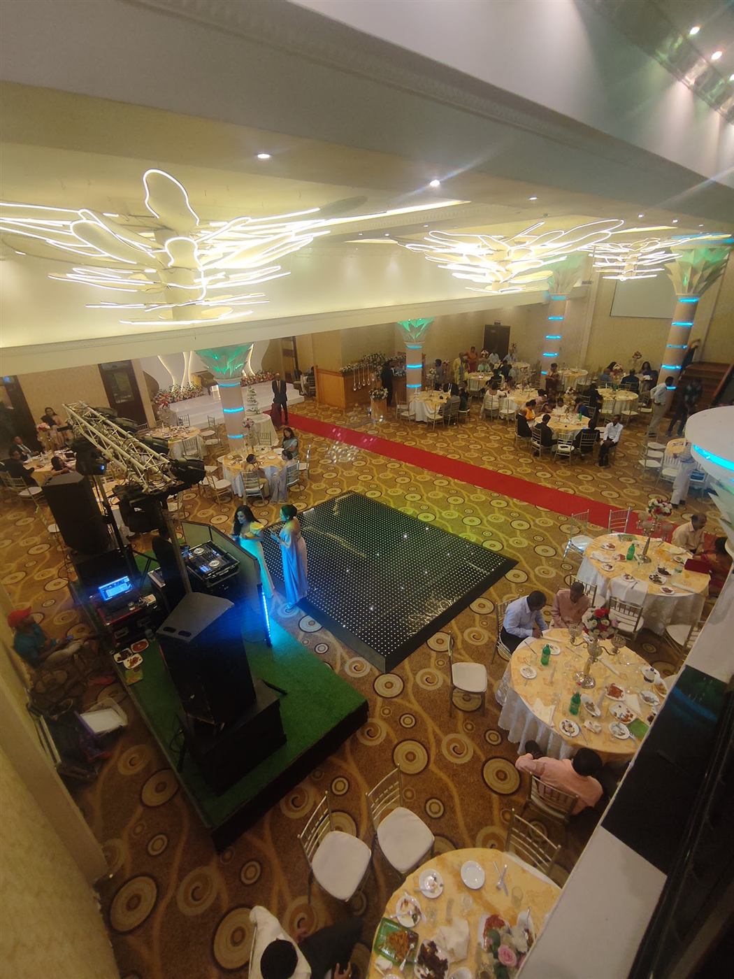 The banquet floor from the balcony, with the red carpet running past the dance floor towards the stage